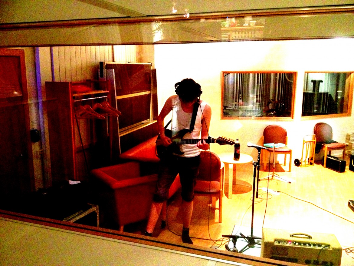 E321 gitarrinspelning med gitarrist i inspelningsrummet i Studio Västerås musikstudio